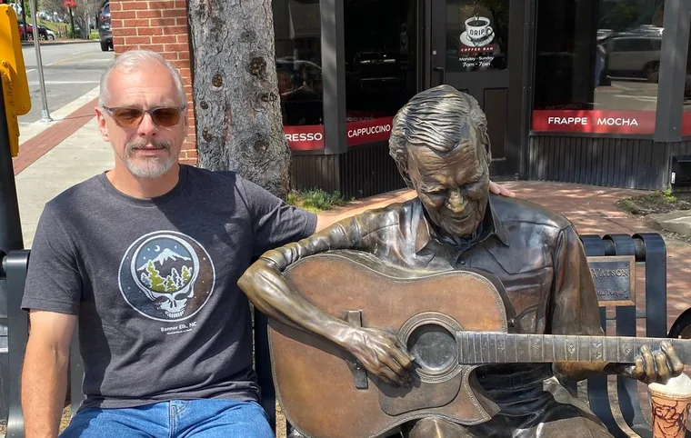 Andy Rockwell beside the Doc Watson statue in Boone, NC
